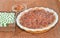 Baked pecan pie, in a yellow and white, glass baking dish pan wicker basket with a pie wedge