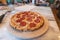 Baked pizza on stone plate sitting on kitchen island