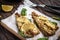 Baked pollock fillet with lemon and spinach on a wooden background