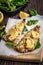 Baked pollock fillet with lemon and spinach on a wooden background