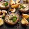 Baked portobello mushrooms stuffed with cheese and herbs on a black background, close-up.