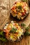 Baked portobello mushrooms stuffed with quinoa, vegetables and cheese with herbs on a wooden board, vegetarian food