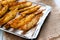 Baked potato wedges on tray - homemade organic vegetable, vegan potato wedges snack