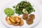 Baked potatoes, falafels, pea mousse and salad on white plate