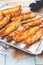 Baked potatoes on tray with black peppers and garlic on rustic wooden board. Vegan food or snack. Healthy