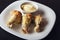 Baked poultry meat and mayonnaise on white plate. Delicious and dietary lunch or dinner on dark background