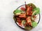 Baked quail on a white round plate on a light gray background