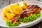 Baked rabbit saddle and vegetable salad on wooden table