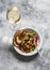 Baked ratatouille, grilled bread and glass of wine - delicious vegetarian appetizers, lunch, snack on a grey background, top view