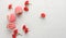 Baked red strawberry macarons and rosebuds on a white table, gourmet almond flour dessert, close up