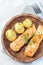 Baked salmon in creamy sauce with young boiled  potato topped with melted butter and chopped dill on a wooden plate, vertical, top