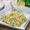 Baked salmon with macadamia cilantro crust in baking dish, square format