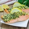 Baked salmon with macadamia cilantro crust on white plate, square format