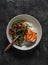 Baked salmon, rice and stir fry teriyaki vegetables on a dark background, top view. Delicious asian style lunch