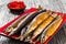 Baked saury on a red rectangular dish , close-up top view