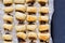 Baked sausage rolls on black table - Top view photo of puff pastry snacks in foil lined tin