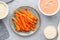 Baked season carrot sticks with sauce and hummus