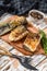 Baked sliced silver carp. Wooden background. Top view