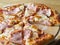 baked and sliced â€‹â€‹pizza with cheese, ham and sauce