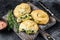 Baked Spanakopita spiral filo pastry puff pie with feta cheese and spinach. Black background. Top view