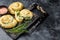 Baked Spanakopita spiral filo pastry puff pie with feta cheese and spinach. Black background. Top view. Copy space