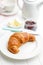 Baked tasty croissant on plate on white table