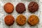 Baked vegan burgers, cutlets made of beetroot, green peas, carrots, groats and herbs on white parchment, top view.