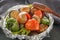 Baked vegetables in foil - tomatoes, eggplants, peppers on a gray wooden table.