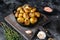 Baked youg potato with thyme in a pan Black background. Top view