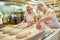 Baker apprentice with boss baking bread under guidance