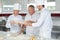 Baker and assistants working in kitchen