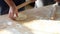 Baker Chef hands preparing fresh dough with rolling pin on kitchen table at cuisine of restaurant bakery.