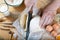 Baker cuts the dough with a knife bread, pizza or pie recipe ingredients with hands, food on kitchen table background, working wit