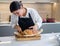 Baker Cuts Freshly Baked Bread With Knife.