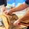 Baker cuts a loaf of baked bread