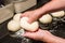 Baker forming bagels from dough