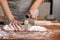 Baker Hand Cutting Raw Dough with a Knife