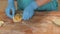 Baker hand forming patty after filling on wooden table in bakery shop close up