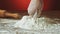 Baker hand preparing flour on the table to make dough slow motion