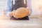 Baker hand wheaten Round loaf of bread lies on table with flour, white kitchen background