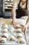 Baker hands at bakery house rolled buns with poppy seeds baking sheet pan wooden table with flour bread white