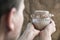 Baker hold in hands glass jar with rye sourdough on brown sackcloth background, leaven starter for organic rustic bread