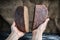 Baker hold in hands two parts of loaf rye whole grain yeast-free sourdough bread in shape of heart cut in half