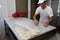 A baker knead dough for cheese pie with roller and flour in bakery in the city of Sofia, Bulgaria â€“ sep 4 , 2015. Chef prepares