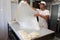 A baker knead dough for cheese pie with roller and flour in bakery in the city of Sofia, Bulgaria â€“ sep 4 , 2015. Chef prepares