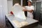 A baker knead dough for cheese pie with roller and flour in bakery in the city of Sofia, Bulgaria â€“ sep 4 , 2015. Chef prepares