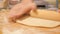 Baker kneading dough in flour on table