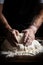 A baker kneads dough on a flour-dusted wooden table, hands covered in flour