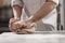 Baker  kneads  dough on the table in the bakery