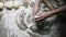 Baker makes ball of fresh dough on table view from above